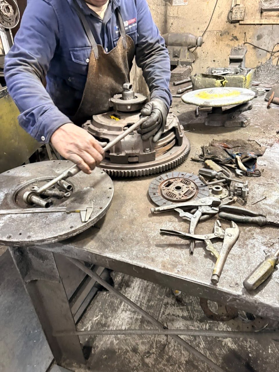 Mecánico de Solo Clutch armando una prensa de embrague sobre el volante de motor