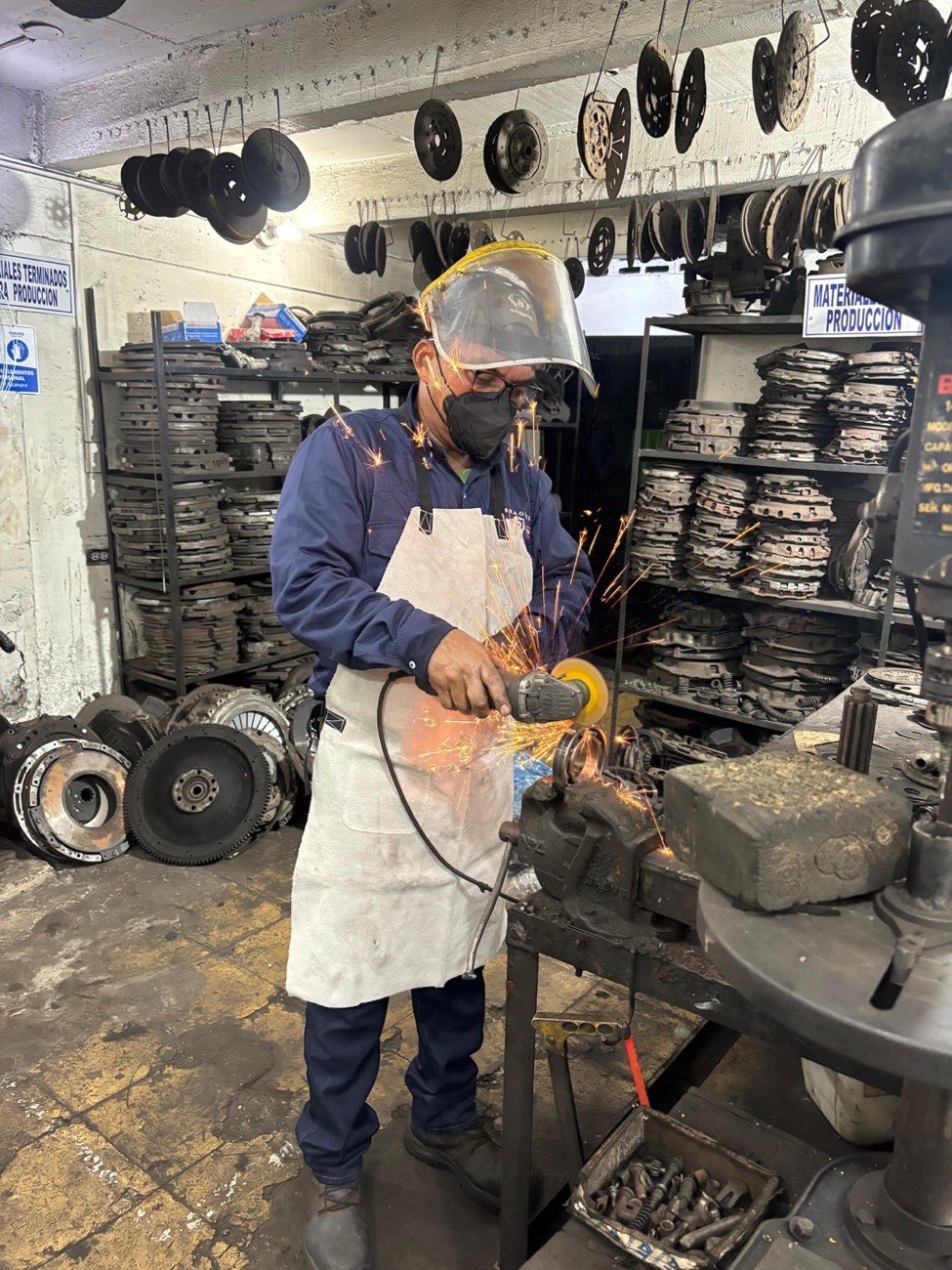 Técnico puliendo componentes de embrague con equipo de protección